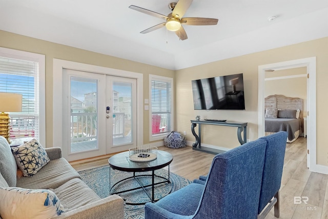 living room featuring light hardwood / wood-style flooring, ceiling fan, and french doors