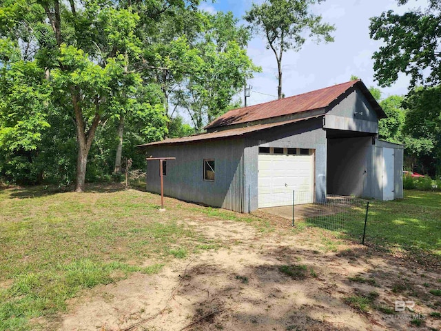 exterior space with an outdoor structure, a lawn, and a garage