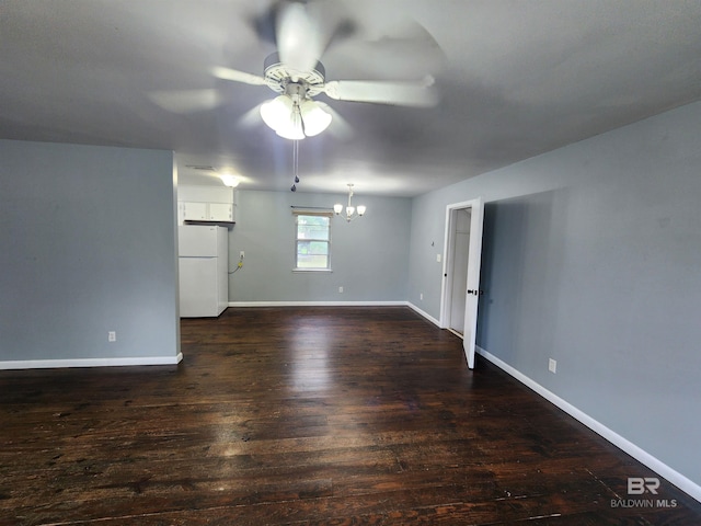 empty room with ceiling fan with notable chandelier and dark hardwood / wood-style flooring