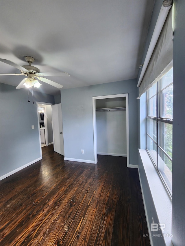 interior space with dark hardwood / wood-style floors, ceiling fan, and a closet