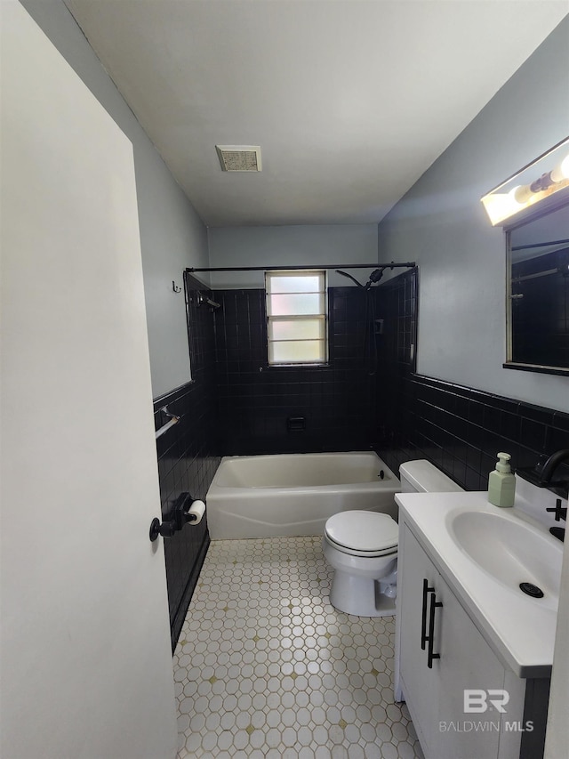 full bathroom featuring tile floors, toilet, vanity, and tiled shower / bath