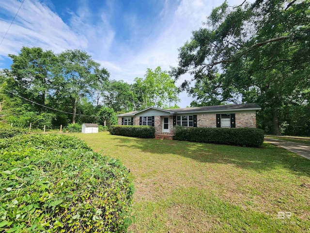 single story home featuring an outdoor structure and a front lawn