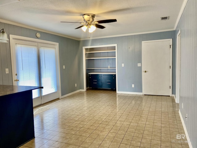 unfurnished living room with light tile patterned flooring, crown molding, visible vents, and a ceiling fan