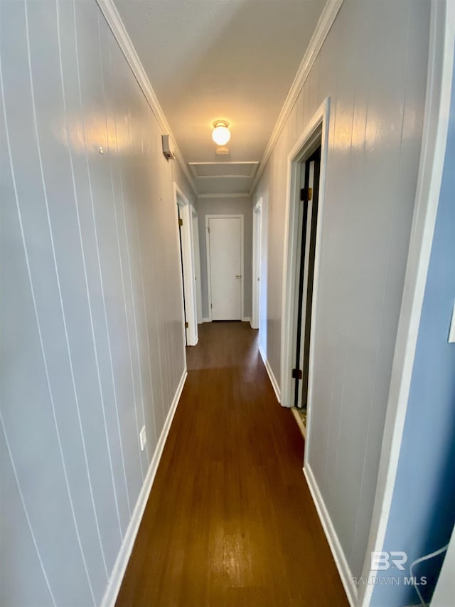 corridor with baseboards, crown molding, and wood finished floors