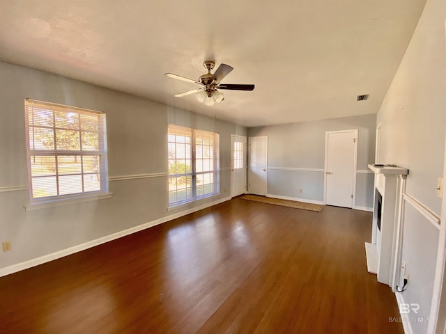 unfurnished room with dark wood-style flooring, baseboards, a ceiling fan, and visible vents