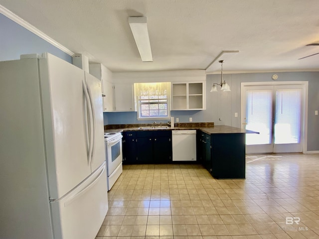 kitchen with a sink, white appliances, ornamental molding, light tile patterned floors, and dark countertops