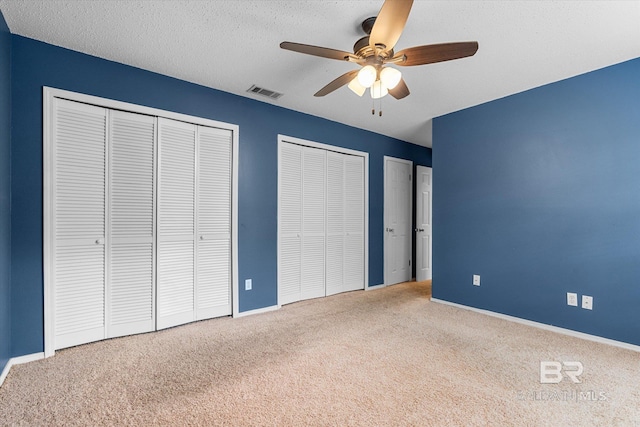 5645 Green Tree Rd, Mobile, AL 36609 - unfurnished bedroom with carpet flooring, two closets, baseboards, ceiling fan, and a textured ceiling