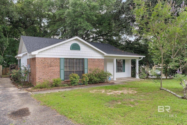 5645 Green Tree Rd, Mobile, AL 36609 - ranch-style home featuring brick siding, a front yard, a shingled roof, and view of scattered trees