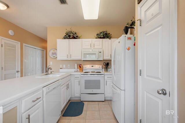 kitchen featuring white cabinets, white appliances, sink, and light tile patterned floors