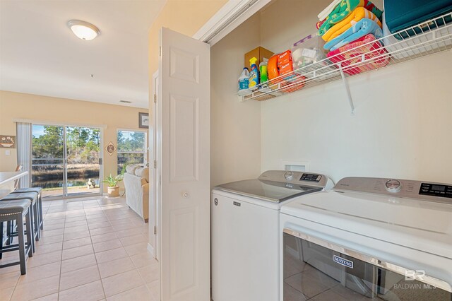 laundry room featuring separate washer and dryer and light tile patterned floors