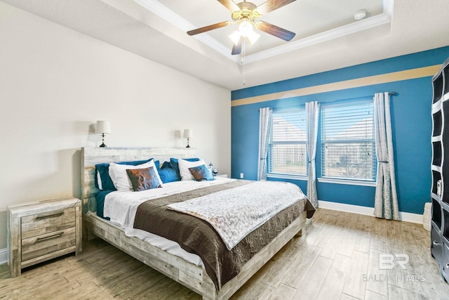 bedroom with a raised ceiling, ceiling fan, crown molding, and hardwood / wood-style flooring