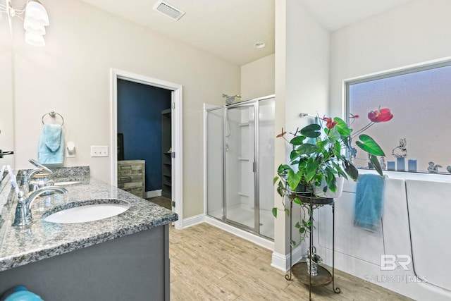 bathroom featuring hardwood / wood-style floors, vanity, and walk in shower