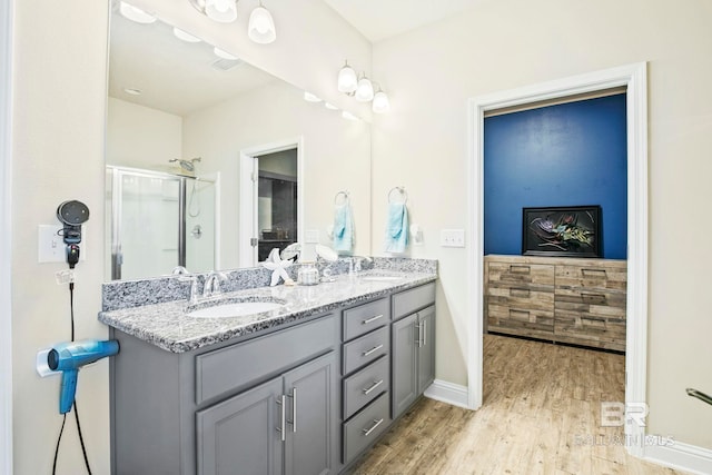 bathroom with a shower with door, vanity, and hardwood / wood-style flooring