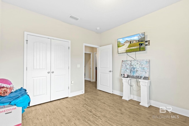 unfurnished bedroom with a closet and light wood-type flooring