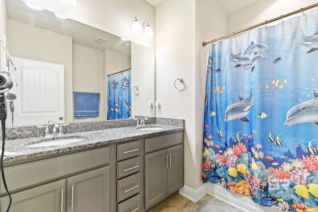 bathroom featuring wood-type flooring, vanity, and shower / tub combo