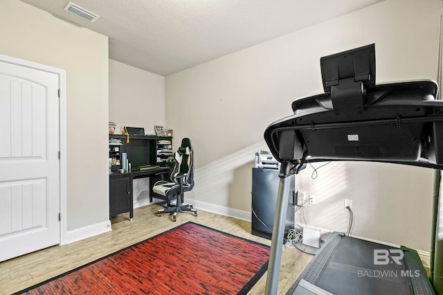 office with hardwood / wood-style floors and a textured ceiling