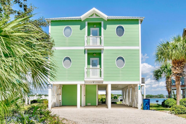 raised beach house featuring a carport and a balcony