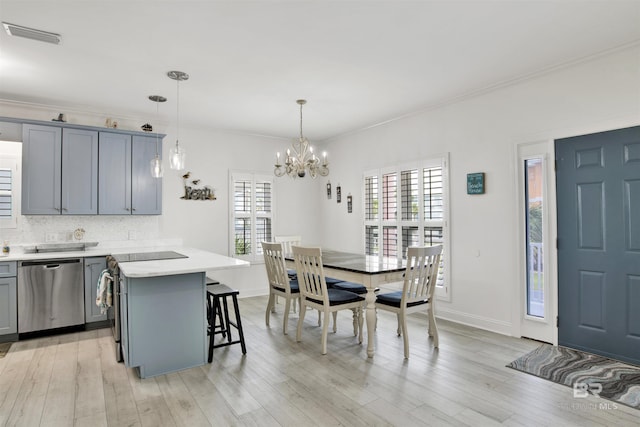 kitchen featuring dishwasher, a center island, a breakfast bar, hanging light fixtures, and a notable chandelier