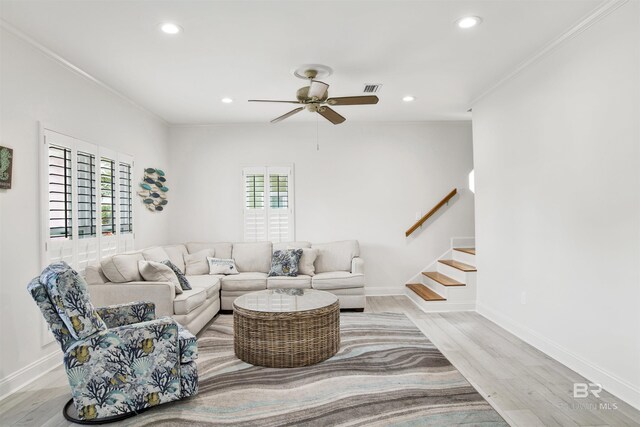 living room featuring crown molding, ceiling fan, and light wood-type flooring