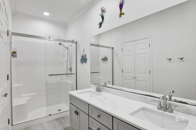 bathroom featuring crown molding, vanity, a shower with shower door, and wood-type flooring