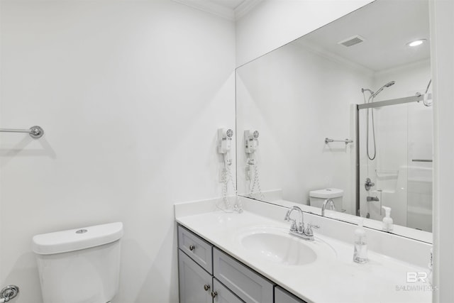 bathroom with crown molding, a shower with door, vanity, and toilet