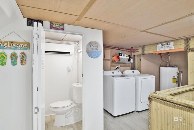 laundry area with light wood-type flooring, separate washer and dryer, and water heater