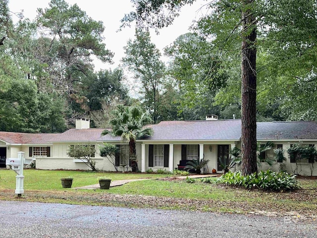 single story home with a front lawn and covered porch