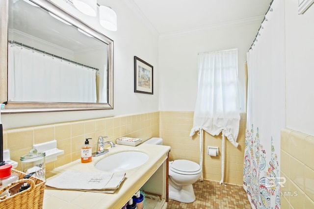 bathroom featuring toilet, sink, tile walls, and ornamental molding