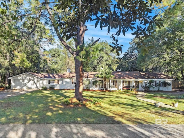 single story home with a garage and a front lawn