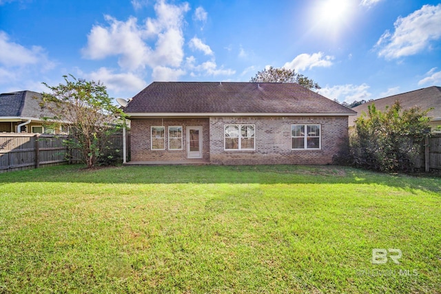 back of property featuring a lawn