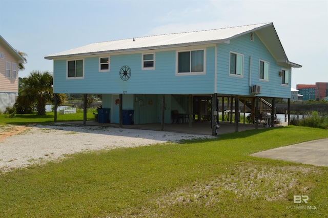 back of property featuring a lawn, a carport, and central air condition unit