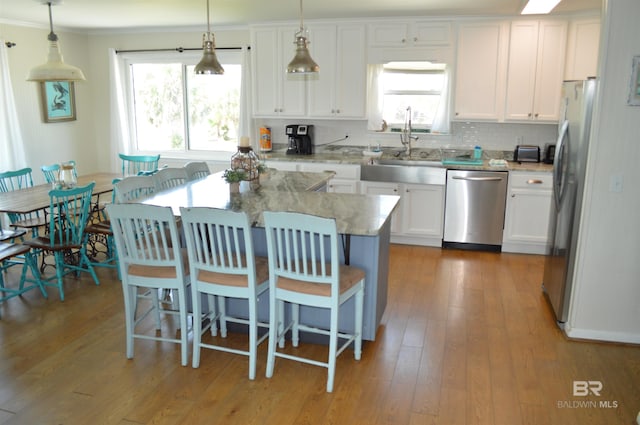 220 Shoreland Cir, Gulf Shores, AL 36542 - kitchen with pendant lighting, a center island, light stone countertops, white cabinetry, and stainless steel appliances