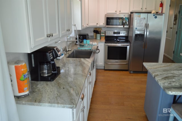 220 Shoreland Cir, Gulf Shores, AL 36542 - kitchen with white cabinetry, sink, light stone countertops, and appliances with stainless steel finishes