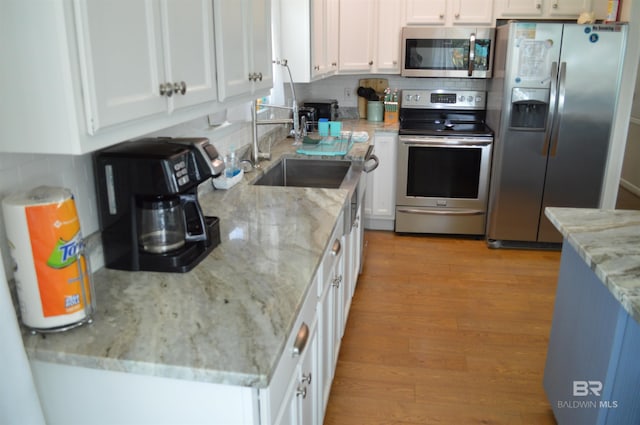 220 Shoreland Cir, Gulf Shores, AL 36542 - kitchen featuring decorative backsplash, sink, white cabinetry, and stainless steel appliances