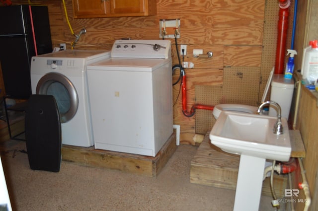 220 Shoreland Cir, Gulf Shores, AL 36542 - clothes washing area featuring separate washer and dryer and wood walls