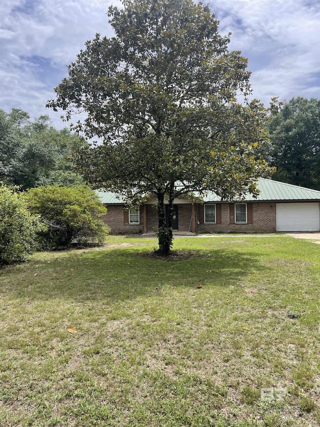 8115 Centeridge Dr, Wilmer, AL 36587 - view of front of home featuring a front yard, a garage, metal roof, and brick siding