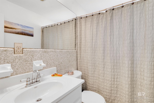 310 W 3rd Ave, Gulf Shores, AL 36542 - bathroom with tile walls, a shower with shower curtain, toilet, and a sink