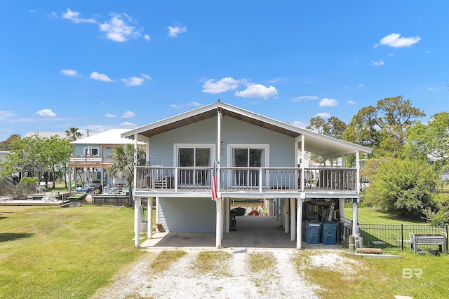 310 W 3rd Ave, Gulf Shores, AL 36542 - back of house featuring a carport, a yard, dirt driveway, and fence
