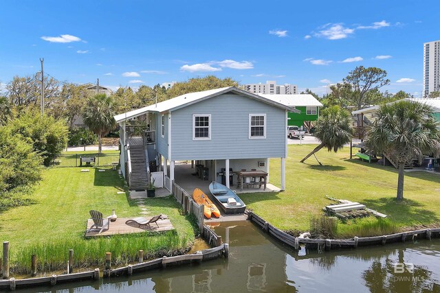 310 W 3rd Ave, Gulf Shores, AL 36542 - rear view of property featuring a patio area, a yard, a water view, and stairs