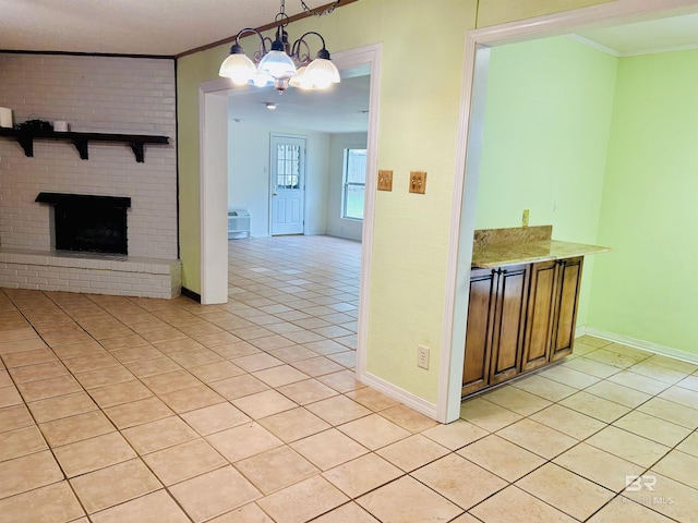 6120 Appaloosa Dr, Mobile, AL 36693 - kitchen with light tile patterned floors, ornamental molding, a chandelier, baseboards, and a brick fireplace