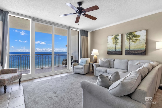 527 E Beach Blvd Unit 802, Gulf Shores, AL 36542 - tiled living area with a water view, a wall of windows, ceiling fan, a textured ceiling, and plenty of natural light