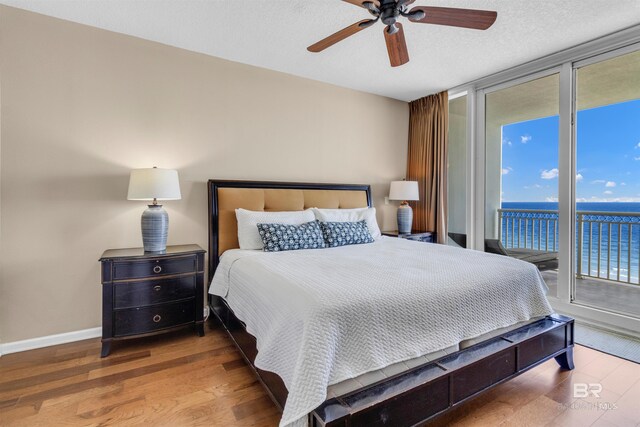 527 E Beach Blvd Unit 802, Gulf Shores, AL 36542 - bedroom featuring access to exterior, a wall of windows, wood finished floors, and a ceiling fan