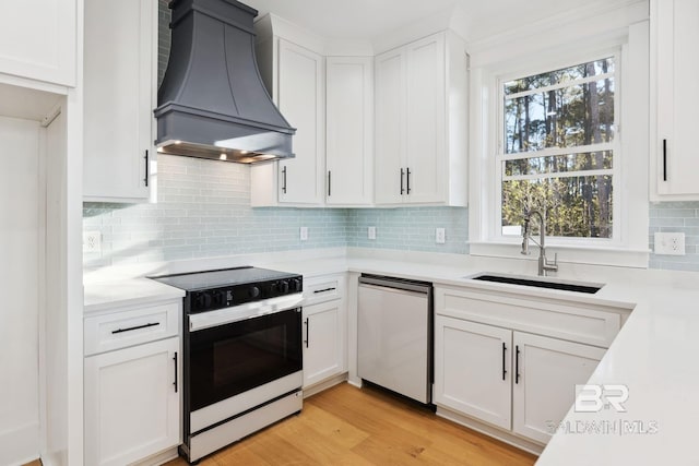 1438 Bienville Blvd Unit B, Dauphin Island, AL 36528 - kitchen with black range with electric stovetop, wall chimney exhaust hood, stainless steel dishwasher, a sink, and light countertops