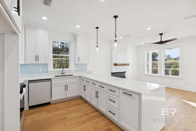 1438 Bienville Blvd Unit B, Dauphin Island, AL 36528 - kitchen with dishwasher, a sink, a peninsula, tasteful backsplash, and white cabinets