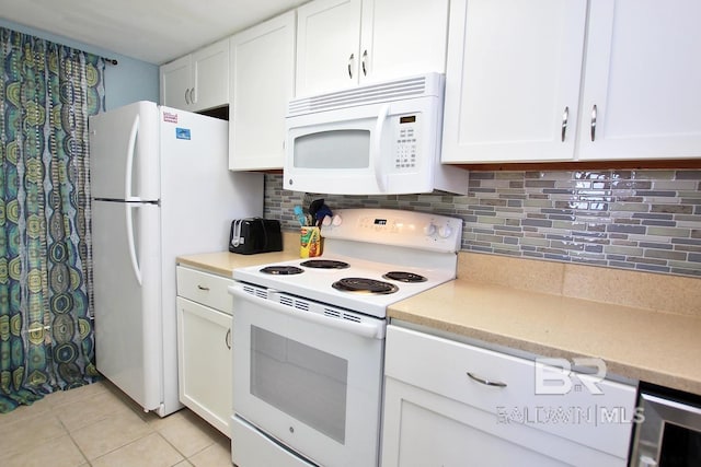 kitchen featuring light tile patterned flooring, white appliances, white cabinetry, and decorative backsplash