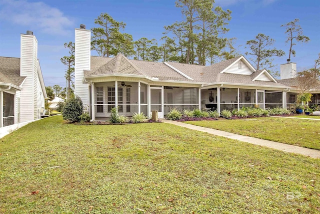 view of front of home featuring a front yard, ceiling fan, and a sunroom