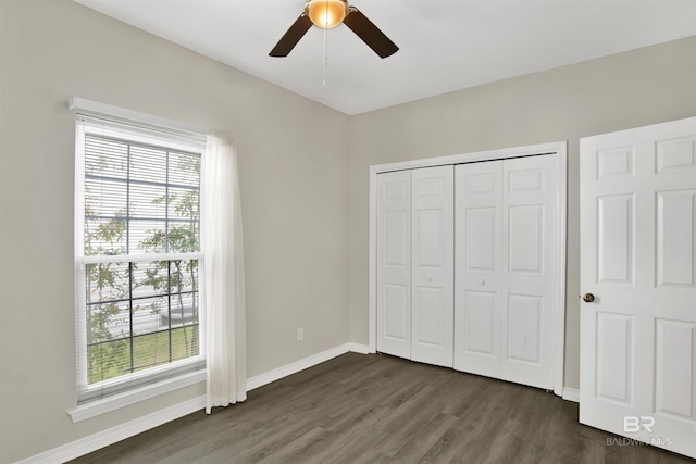 unfurnished bedroom with dark hardwood / wood-style flooring, a closet, and ceiling fan