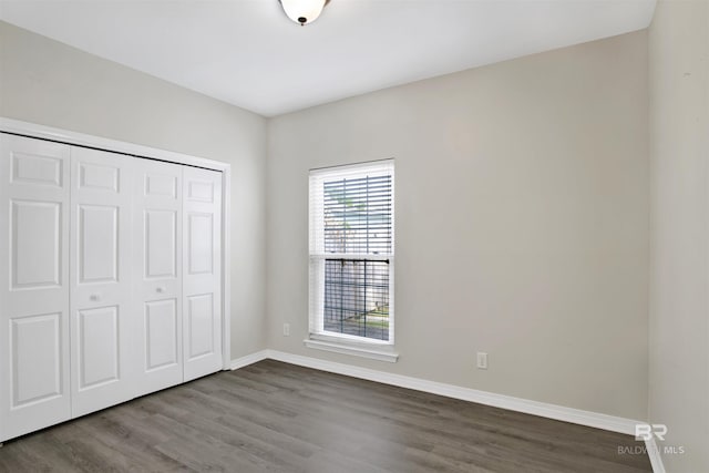 unfurnished bedroom featuring a closet and hardwood / wood-style flooring