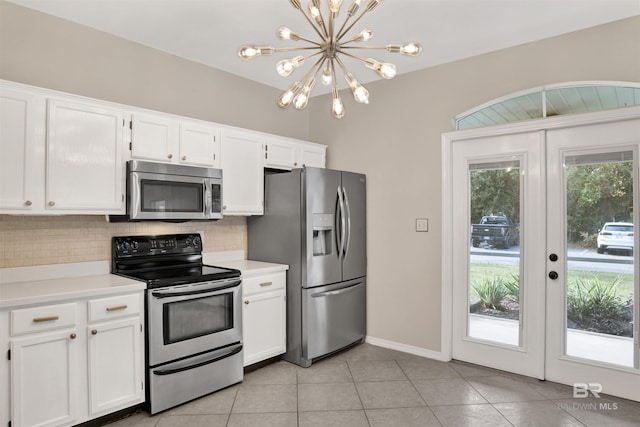 kitchen featuring white cabinets, appliances with stainless steel finishes, and an inviting chandelier