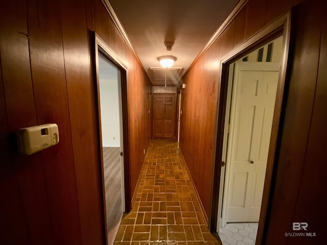 hall featuring ornamental molding and wood walls